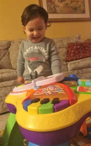 baby playing with music activity center